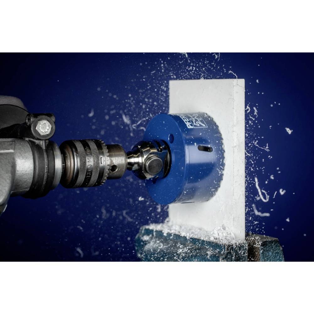 Una testa di perforazione blu taglia in una superficie bianca, mentre l'acqua schizza. Una situazione di perforazione industriale.