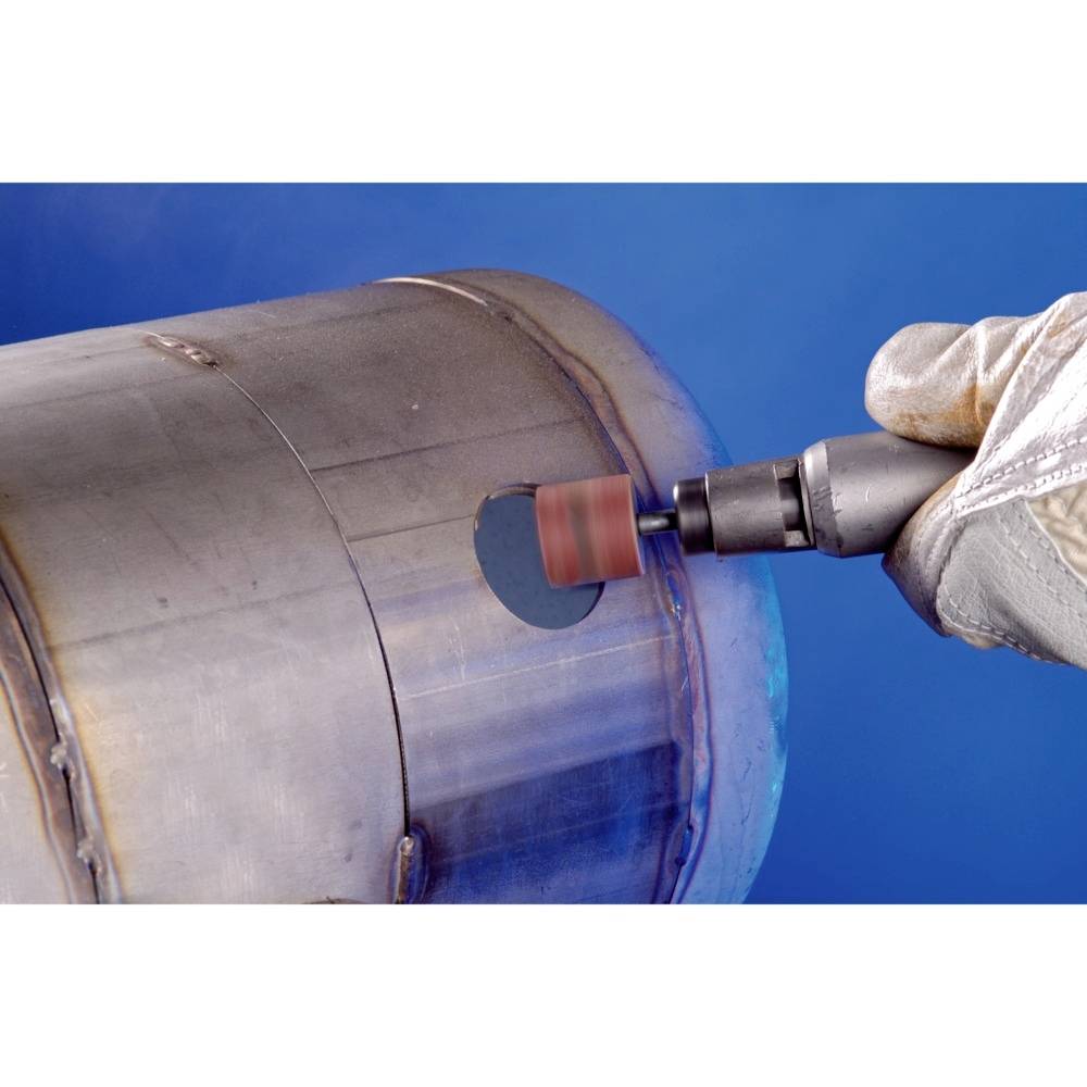 Un tubo metallico rettangolare viene lavorato con un accessorio per levigatura su un trapano. Una persona indossa un guanto durante l'operazione.