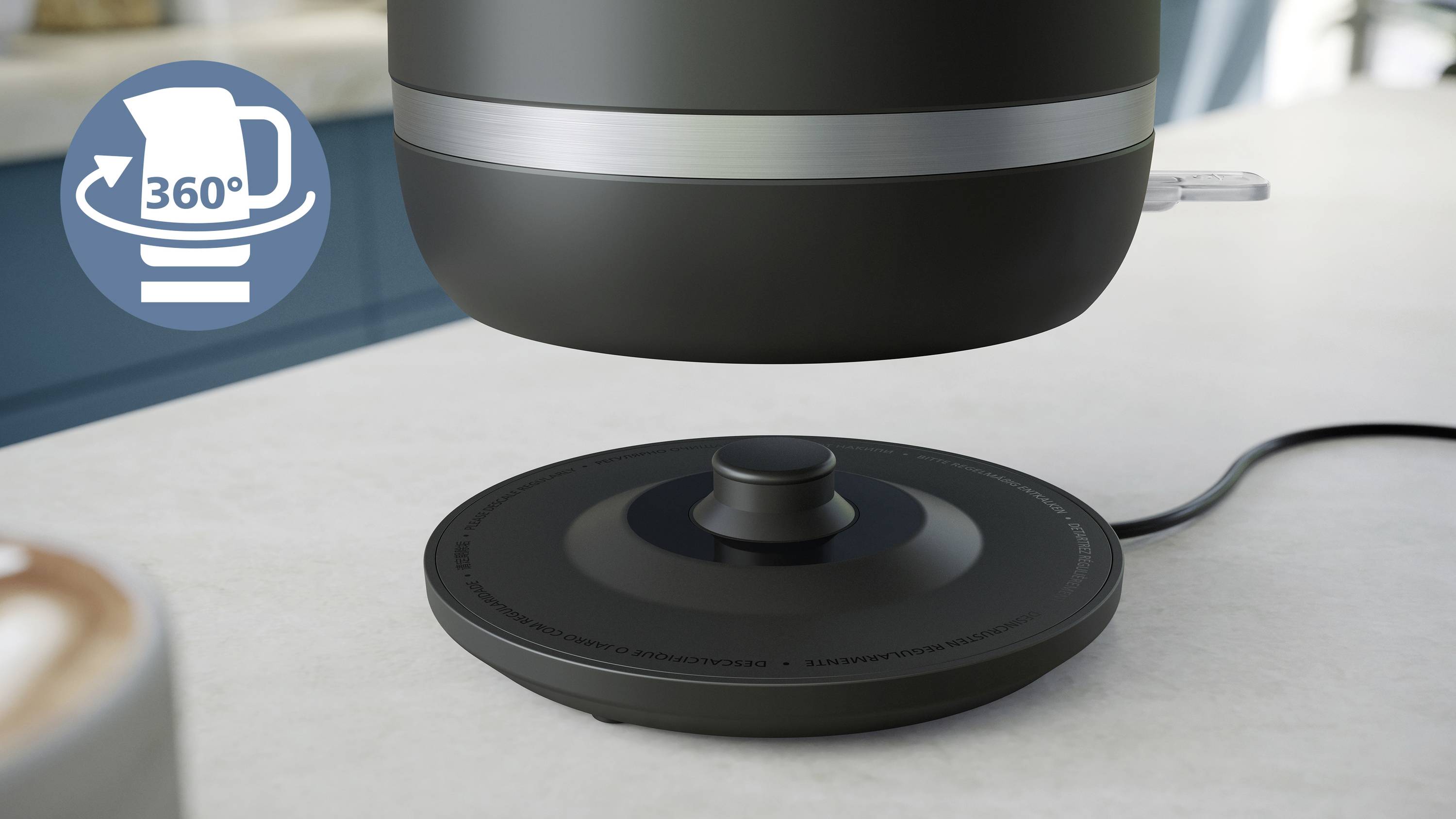 Un bollitore è sospeso sopra la sua base, con un simbolo che indica la rotazione di '360°'; sullo sfondo, una cucina sfocata.