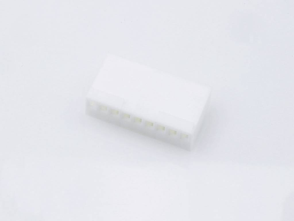 Un connettore bianco in plastica con più punti di contatto è posizionato su una superficie chiara. Adatto per connessioni elettroniche.
