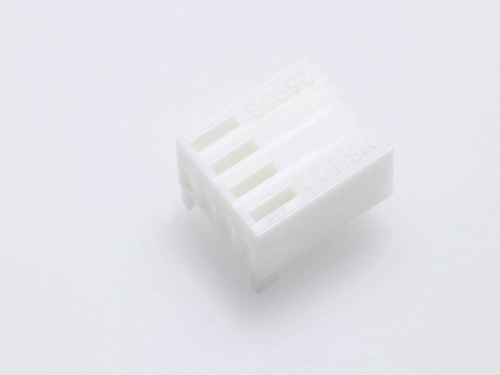 Un connettore bianco in plastica con quattro aperture parallele, adagiato su una superficie chiara.