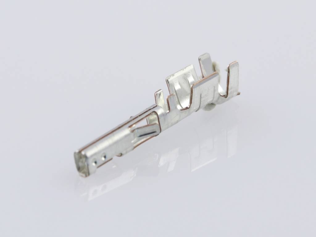 Contatto elettrico metallico a forma cilindrica, con più morsetti, adagiato su uno sfondo chiaro.