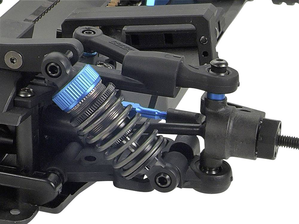 Primo piano di un sistema di sospensione per auto radiocomandato con una molla blu e componenti di ammortizzazione.