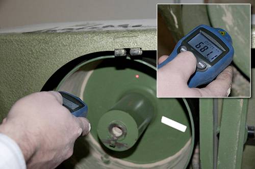 Una persona misura lo spessore di una superficie verde rivestita con uno strumento di misurazione blu. Il display mostra un valore di 680.