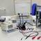 In un laboratorio, su un tavolo c'è un computer aperto con dispositivi elettronici di misurazione e strumenti collegati.