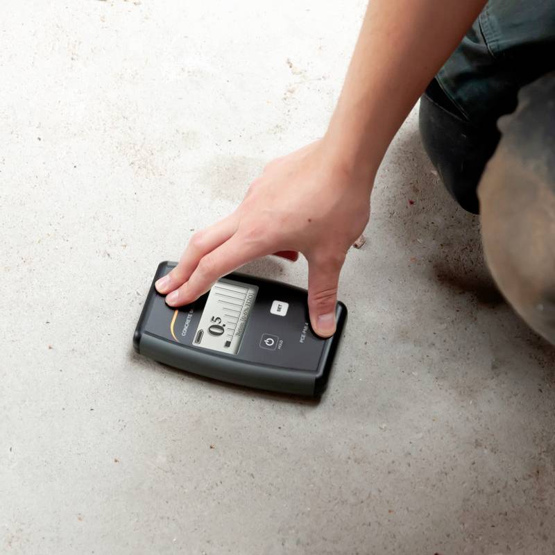 Una persona misura la rugosità di una superficie con uno strumento di misurazione digitale che indica 0,5.