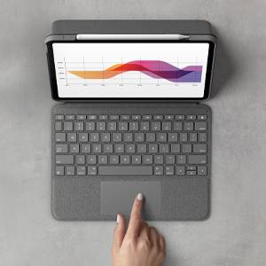 Mano umana che aziona un tablet con una tastiera collegata. Sullo schermo viene visualizzato un grafico a onde colorate con sfumature graduate.