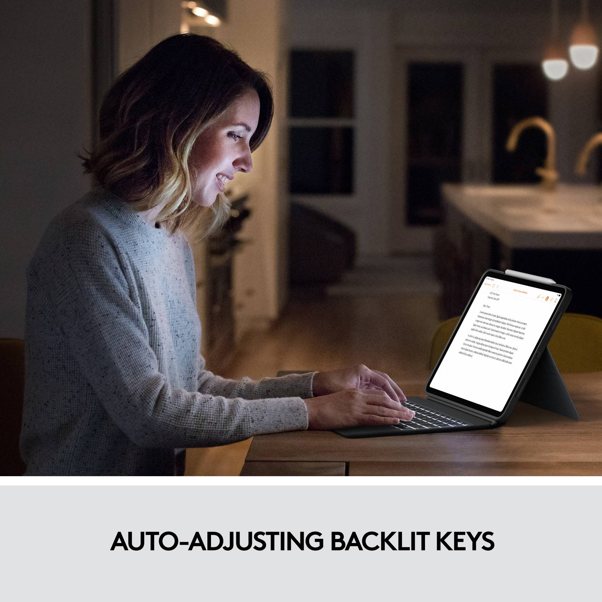 Una donna lavora la sera su un tablet con illuminazione dei tasti regolata automaticamente, che facilita la digitazione in ambienti bui.
