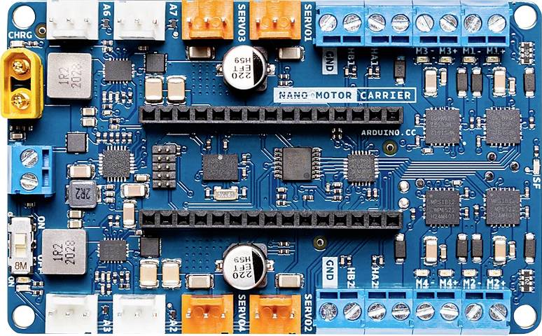 Scheda elettronica con diversi connettori e chip su una superficie blu. Etichetta 'NANO-MOTOR CARRIER' visibile.