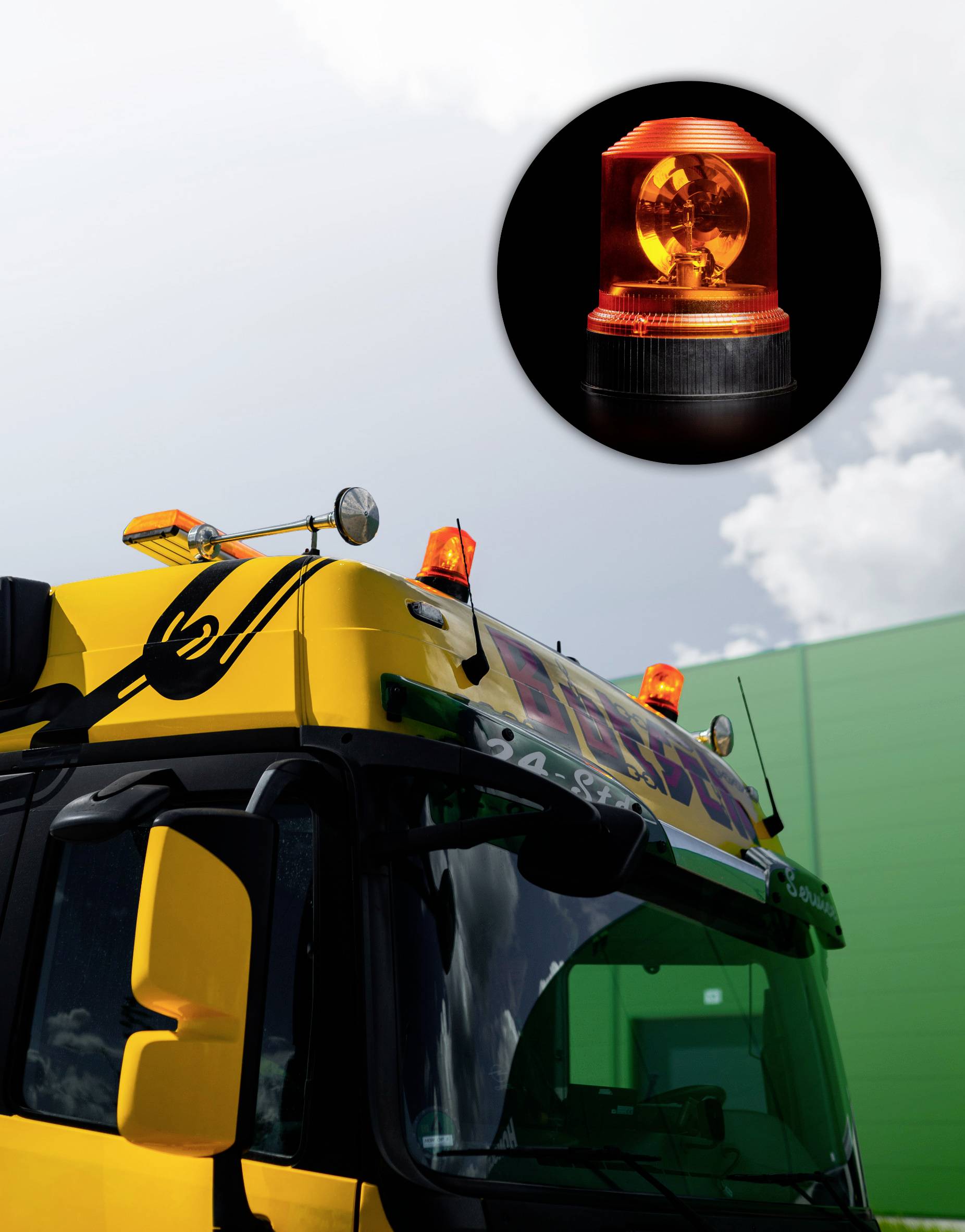 Un veicolo giallo con un lampeggiante arancione sul tetto, davanti a un edificio verde e un cielo nuvoloso.