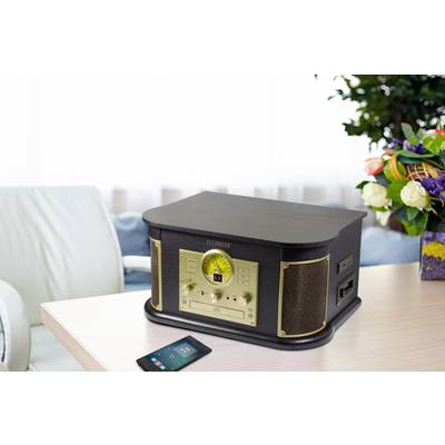 Un radio stereo retrò con cabinet in legno su un tavolo. Accanto è pogato uno smartphone. Sullo sfondo si vedono dei fiori.