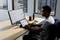 Un uomo lavora in un ufficio con un laptop e un monitor sui quali vengono visualizzate analisi di dati aziendali con grafici e tabelle.