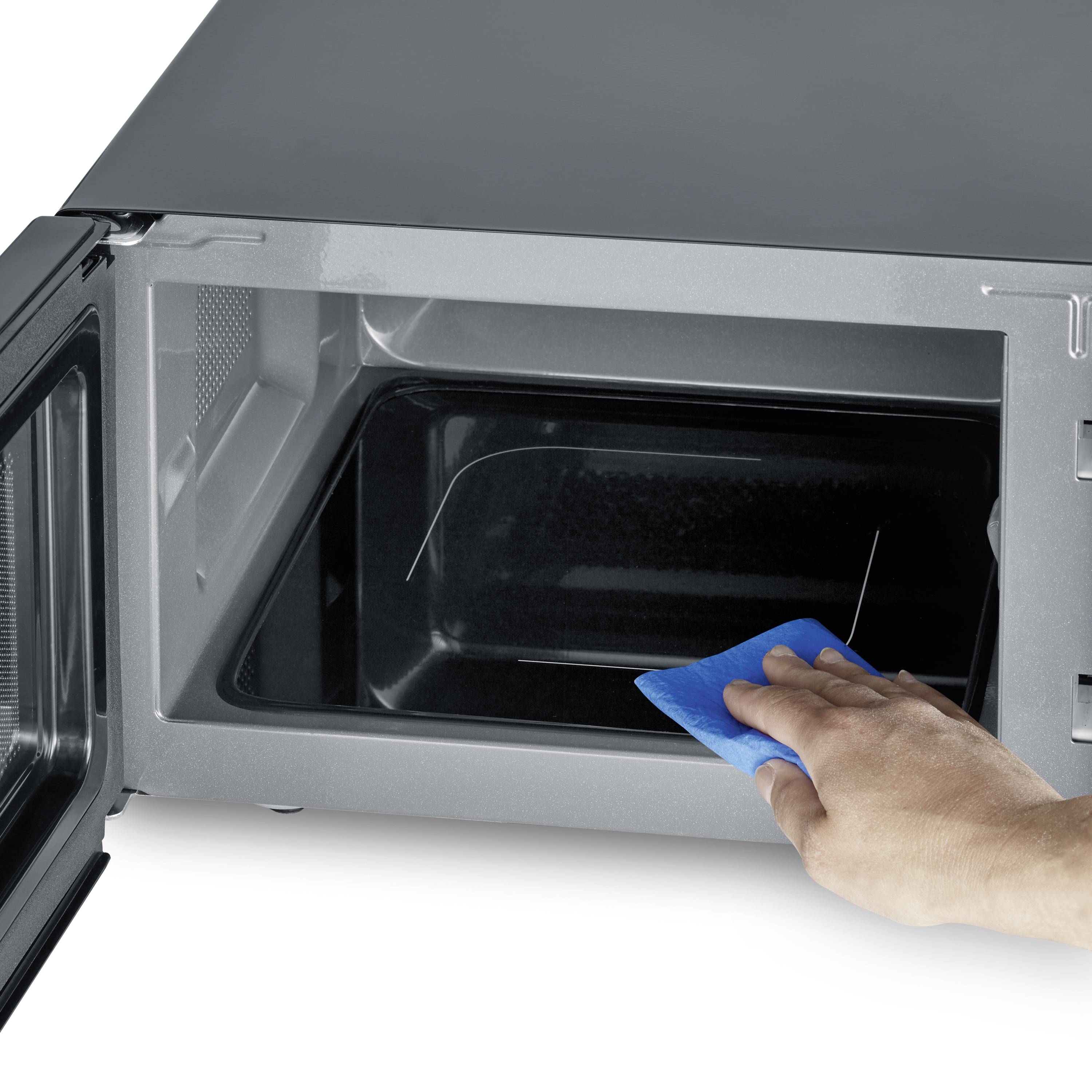 Una persona sta pulendo l'interno di un forno a microonde con un panno blu. Lo sportello del forno a microonde è aperto.