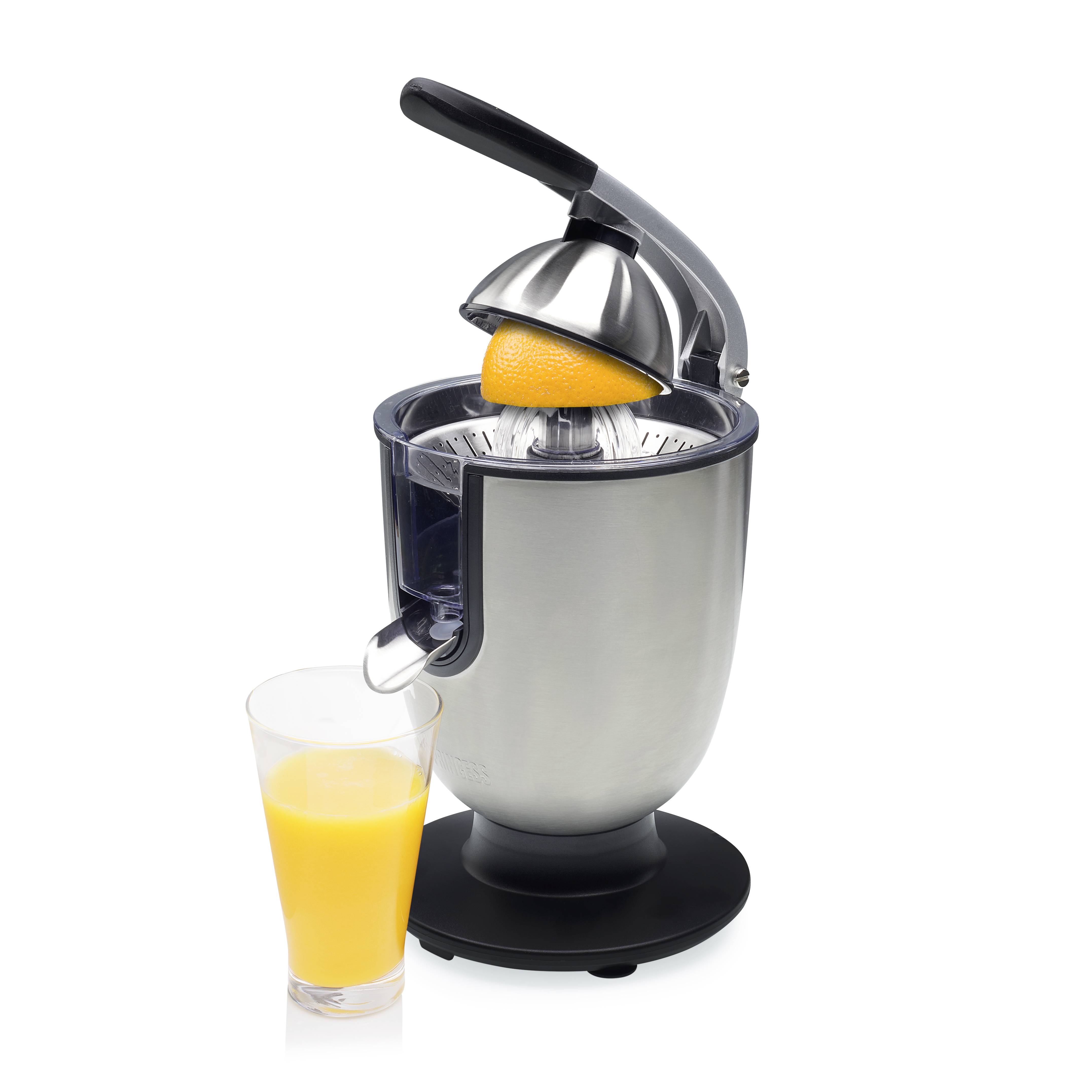 Spremi-agrumi manuale in argento con un mezzo arancio nel meccanismo di spremitura, accanto a un bicchiere di succo d'arancia appena premuto.
