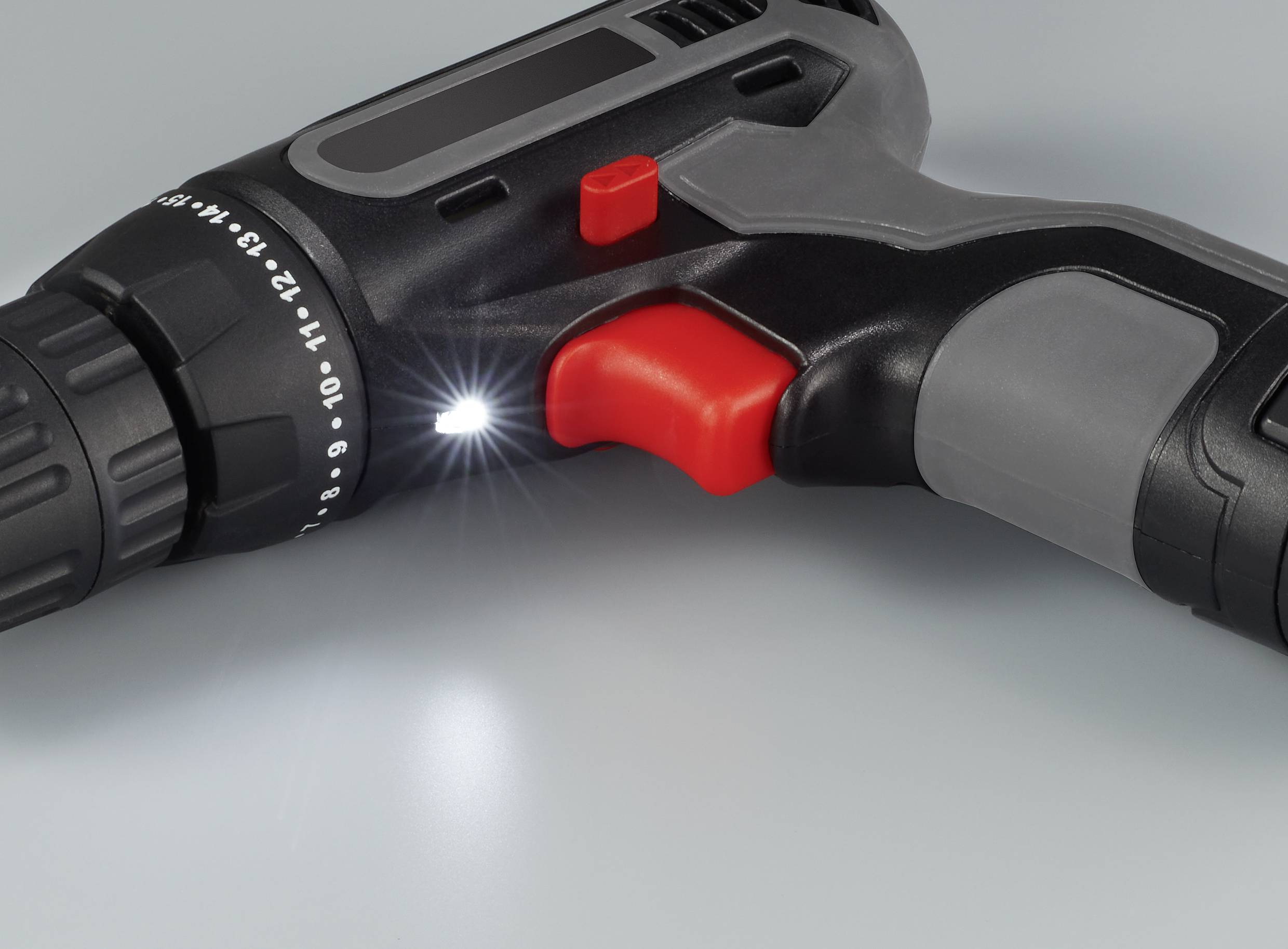 Trapano avvitatore con luce LED, primo piano dell'impugnatura e dell'interruttore, mostra la regolazione della coppia, adatto per lavori fai-da-te.