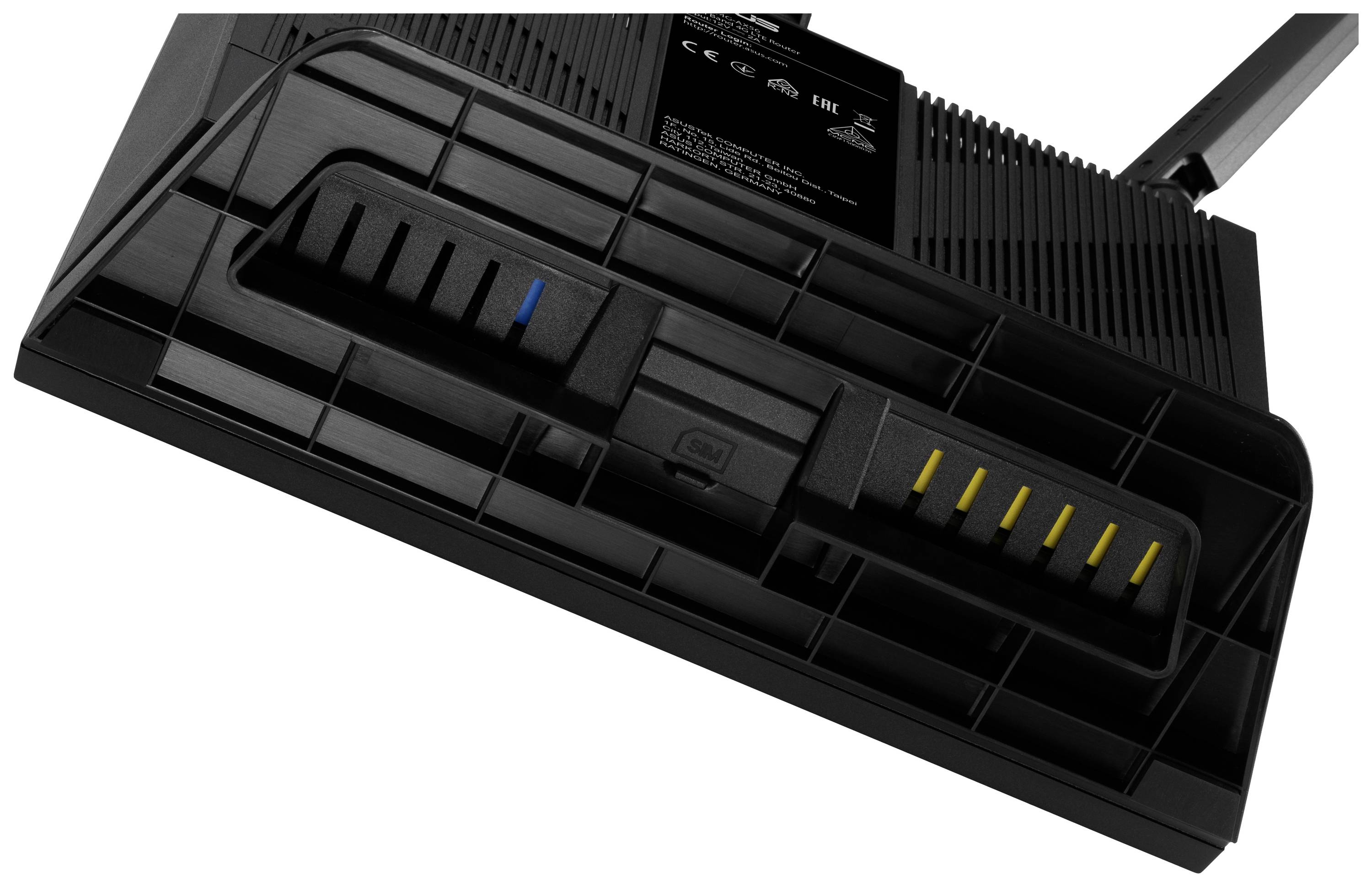 Primo piano della parte inferiore di un router wireless con porte e fori di ventilazione visibili.