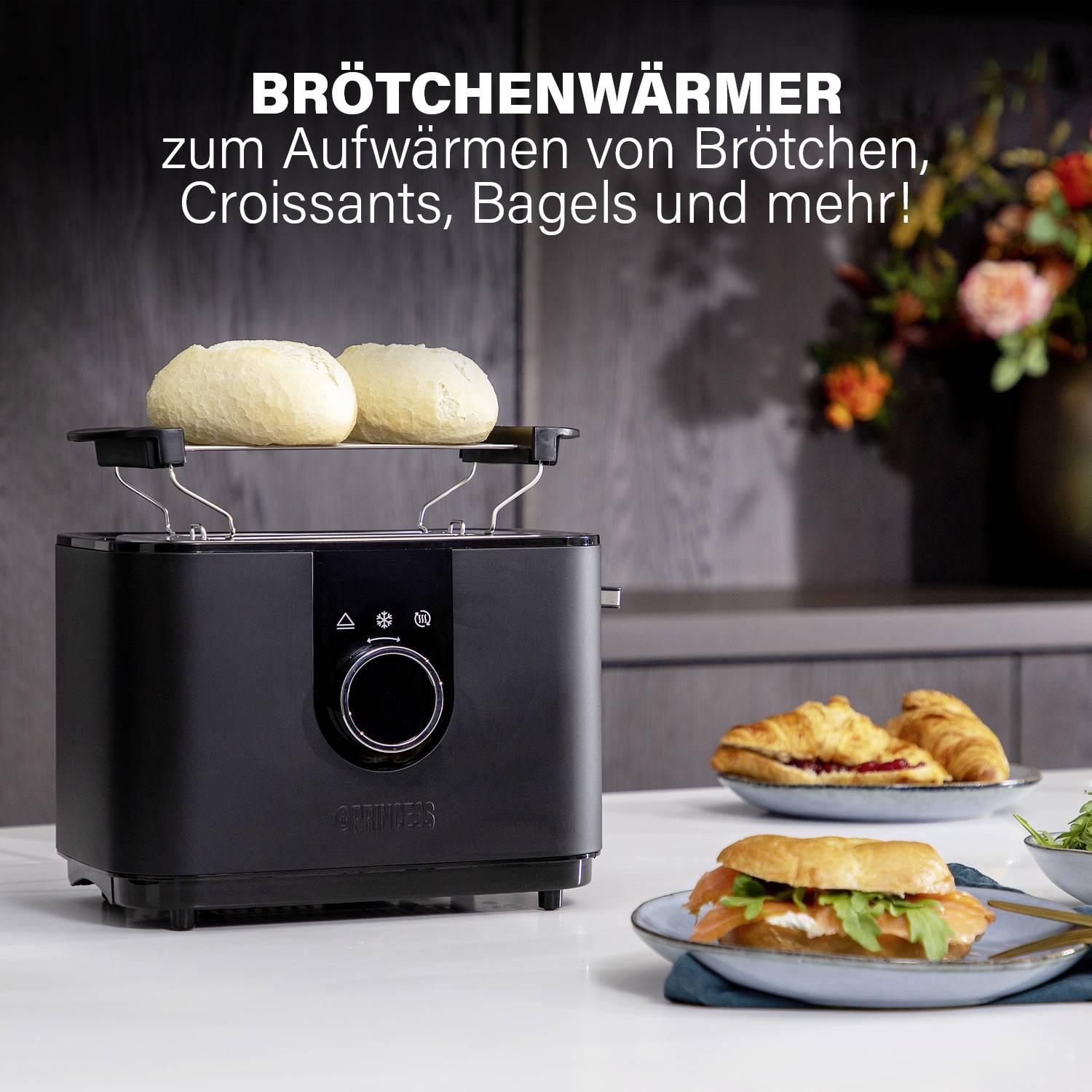 'Scaldapane per riscaldare panini, croissant, bagel e altro!' Un accessorio per panini su un tostapane nero in una cucina moderna.