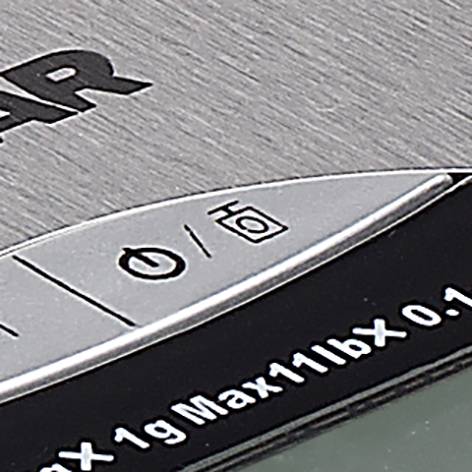 Parte di una bilancia digitale da cucina con tasti di controllo e una sezione del display per la misurazione del peso.