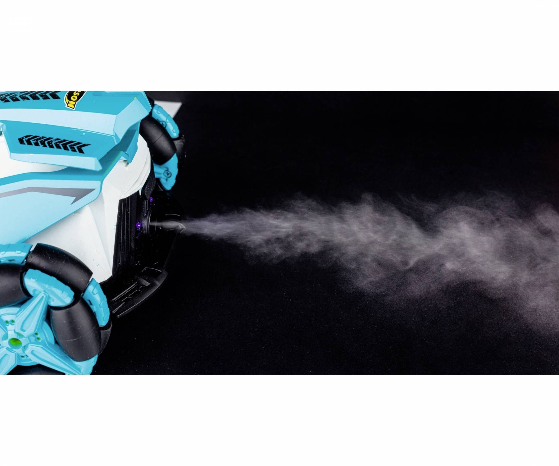 Un dispositivo blu-nero su ruote spruzza fumo o vapore verso destra in un ambiente nero.