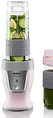 Frullatore rosa con recipiente trasparente. Contiene pezzi di frutta e verdura verdi e gialli. Accanto a esso, una piccola bottiglia con succo verde.