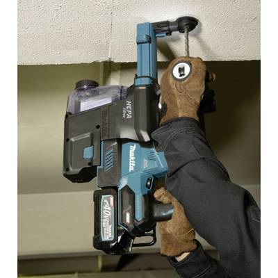 Un lavoratore utilizza un trapano elettrico blu per forare un soffitto. Indossa guanti marroni per la protezione.