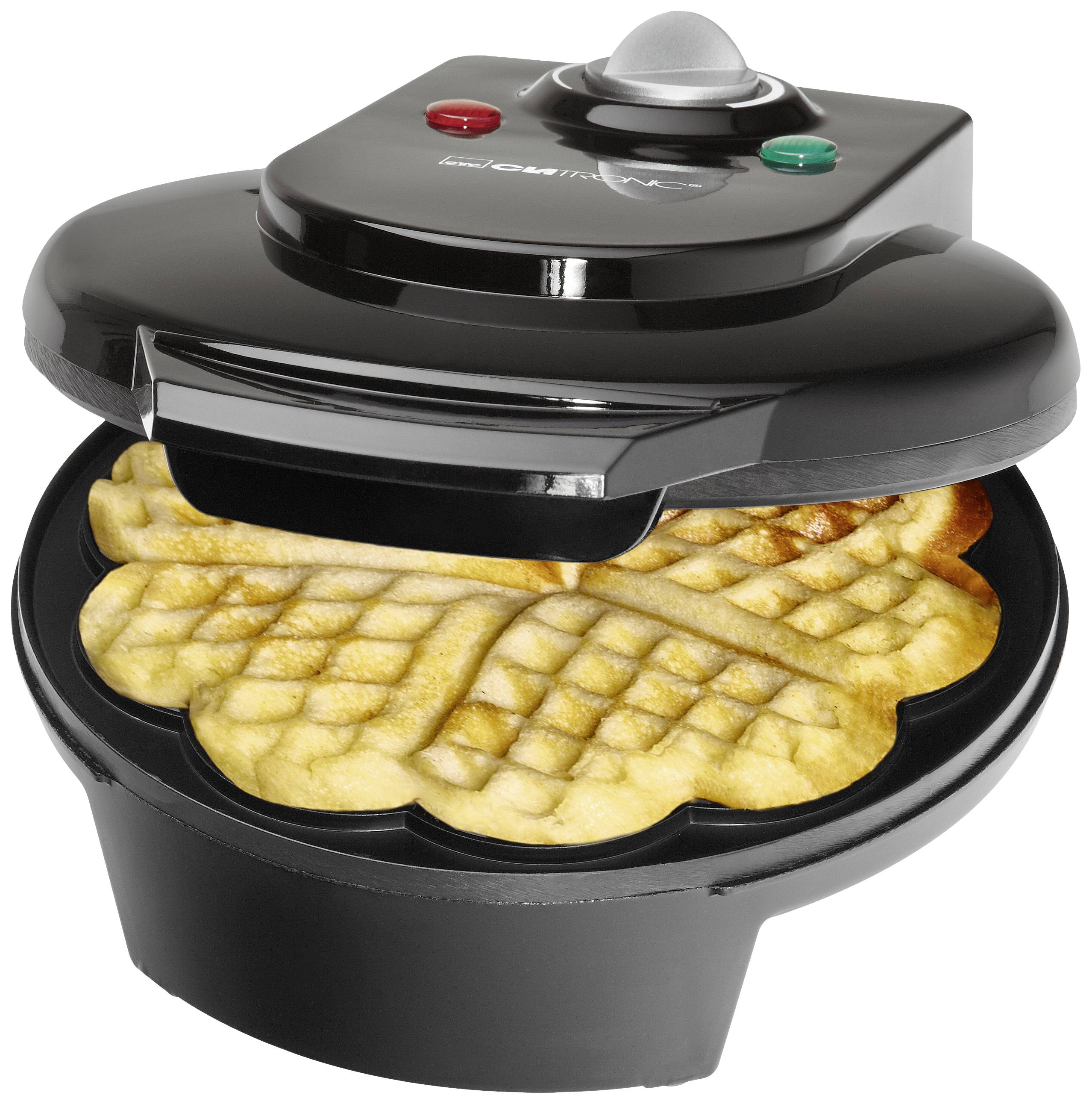 Un ferro per waffle nero con due cialde a forma di cuore appena cotte, aperto. Sono visibili una spia luminosa rossa e una verde.