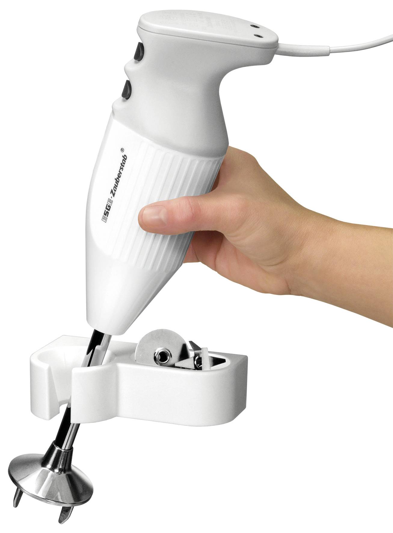 Una mano tiene un frullatore a immersione bianco con testa intercambiabile. Il frullatore viene inserito in un supporto adatto.
