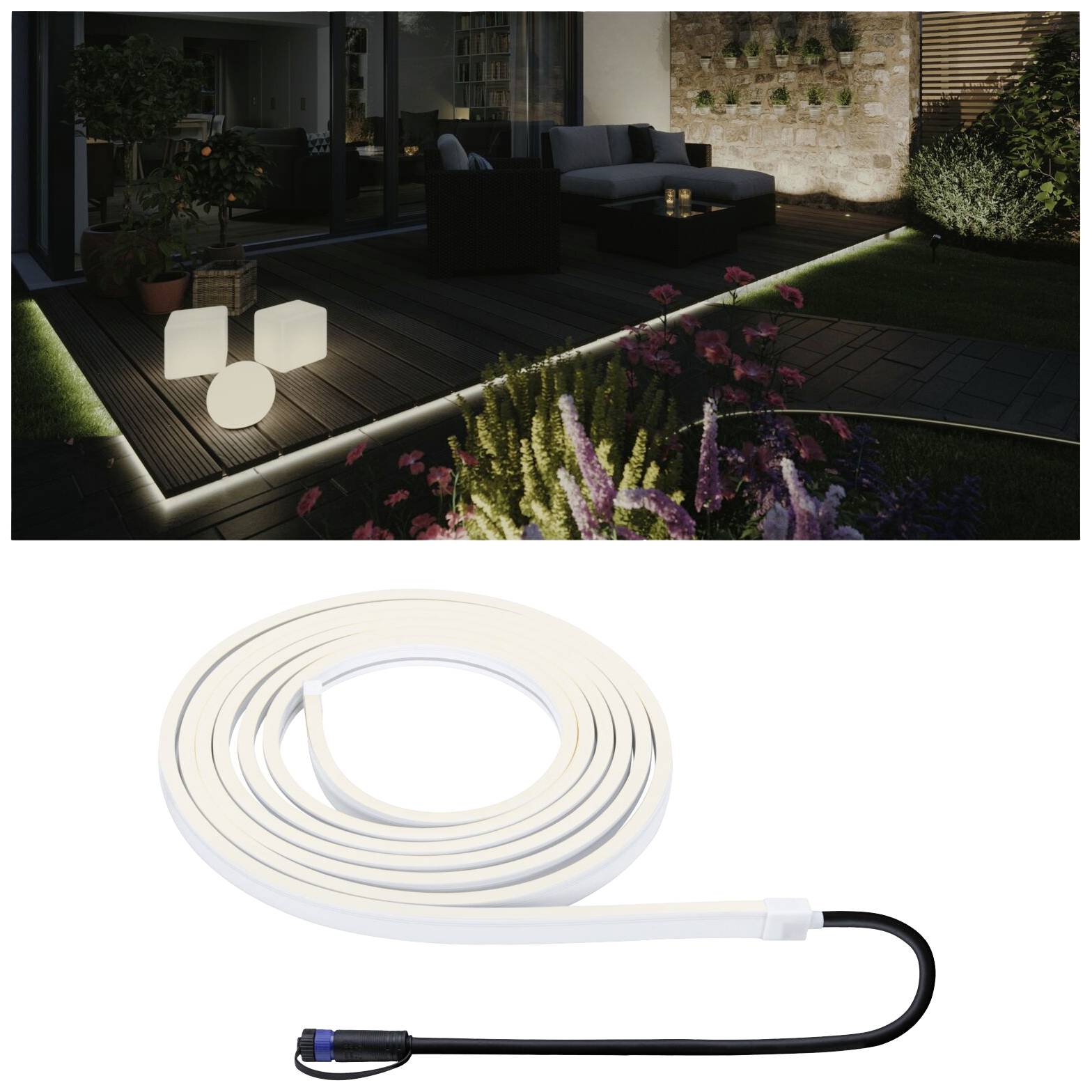 Un giardino illuminato con decorazioni suggestive e piante. In basso nell'immagine, una barra luminosa LED bianca con cavo di collegamento.