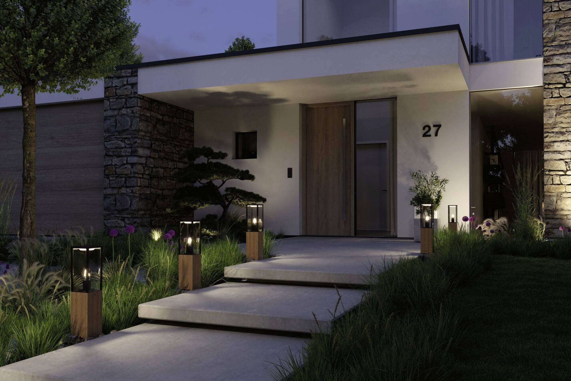 Facciata moderna di una casa di notte, con un vialetto d'ingresso illuminato e gradini, circondato da erba e piante. Numero civico: 27.