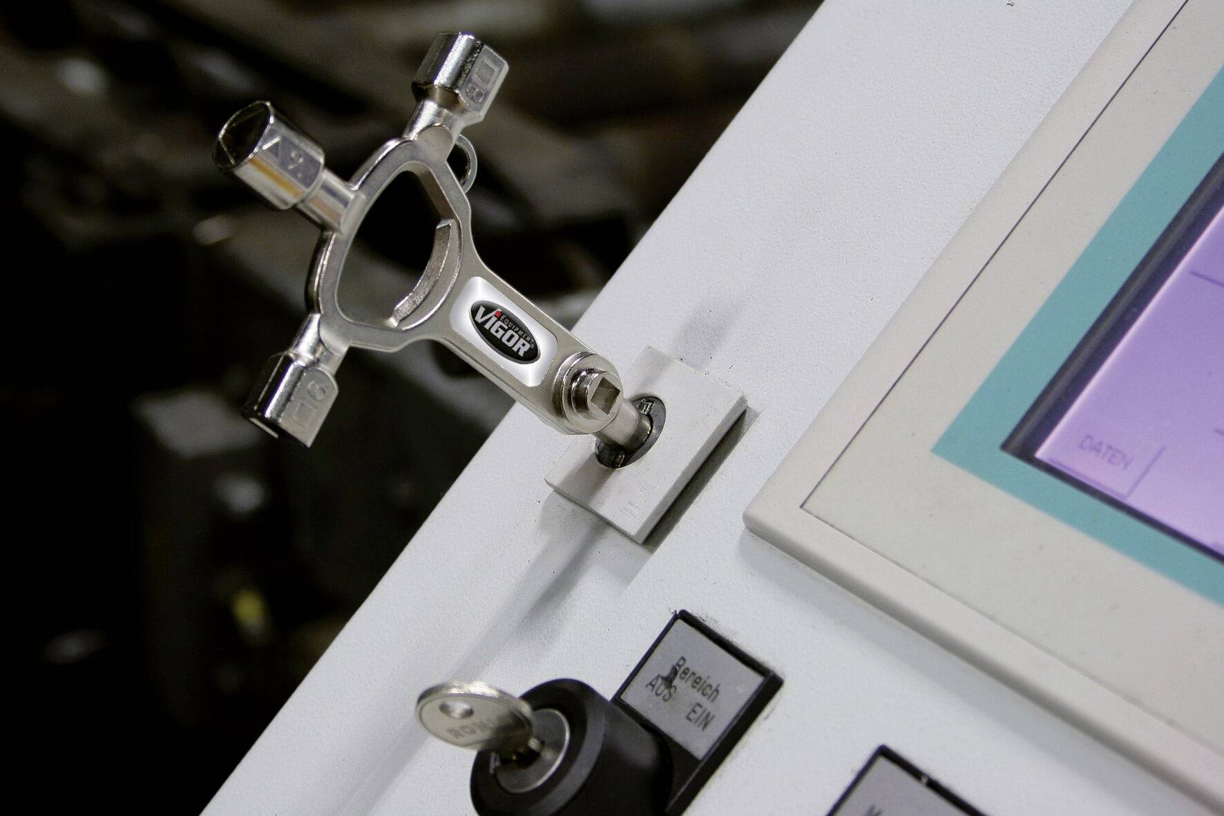 Un pannello di controllo con una chiave principale mostra un dispositivo di bloccaggio in un ambiente industriale. Sul lato destro è presente un display.