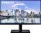 Un monitor Samsung mostra una vista cittadina con alti edifici vicino all'acqua. Il cielo è limpido con alcune nuvole.