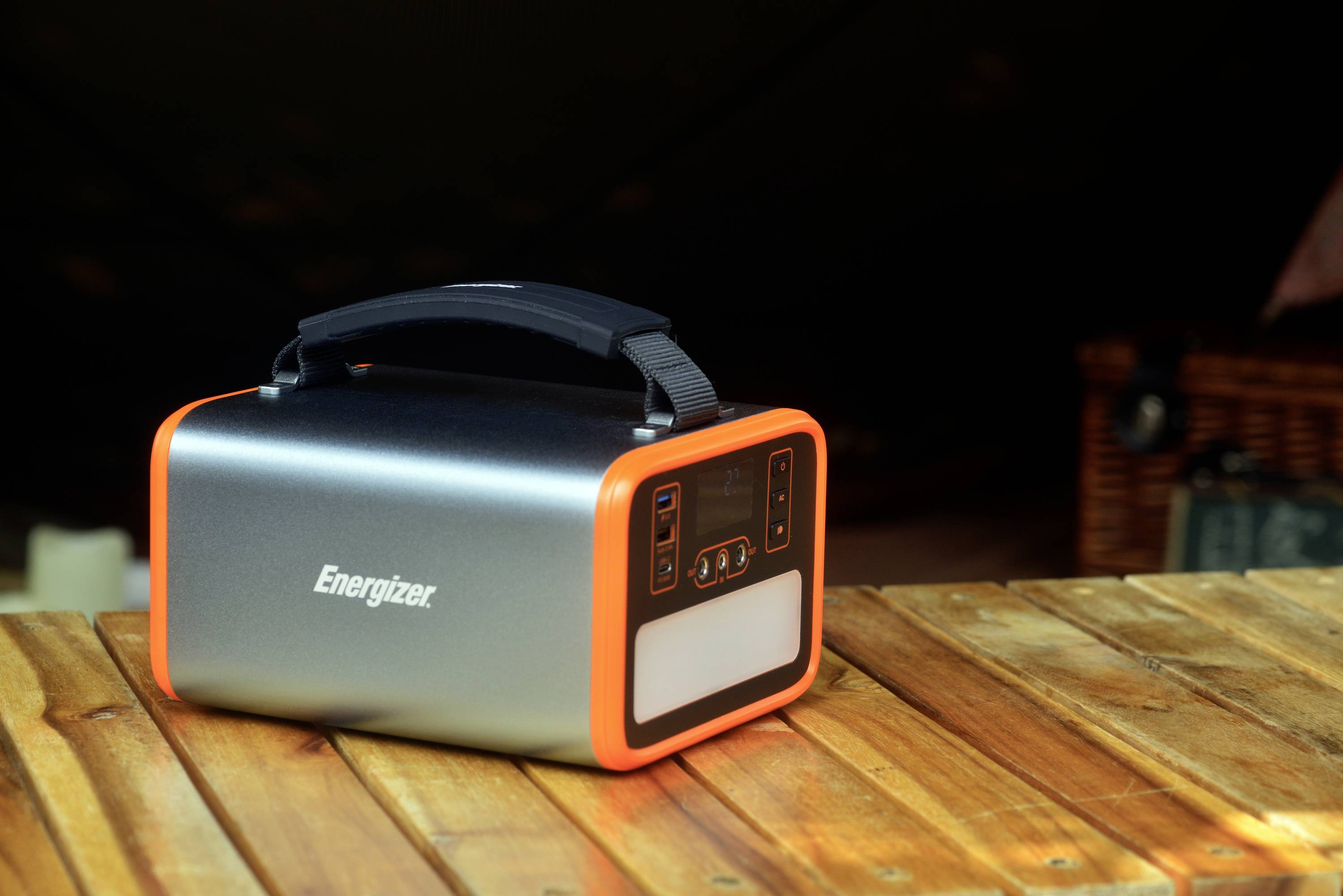 Un accumulatore portatile di Energizer su un tavolo di legno. Ha un manico nero e dettagli di colore arancione.