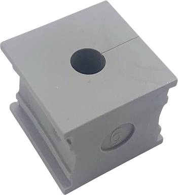 Pezzo grigio in plastica a forma di cubo con un foro al centro e una scanalatura laterale. La superficie superiore mostra una sottile linea di frattura.