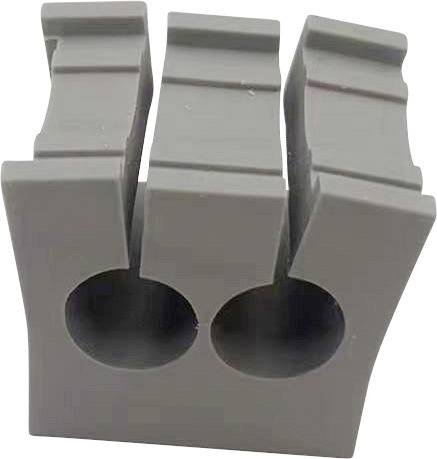 'Blocco grigio in plastica con due fori rotondi e tre scanalature verticali.'