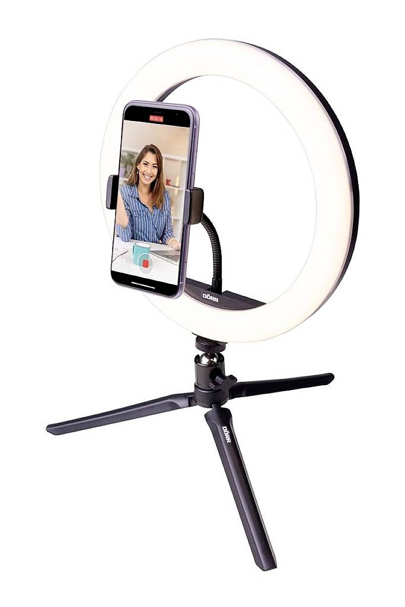 Anello luminoso con supporto per smartphone e treppiede. Uno smartphone è fissato e mostra l'immagine di una persona sorridente durante una videochiamata.