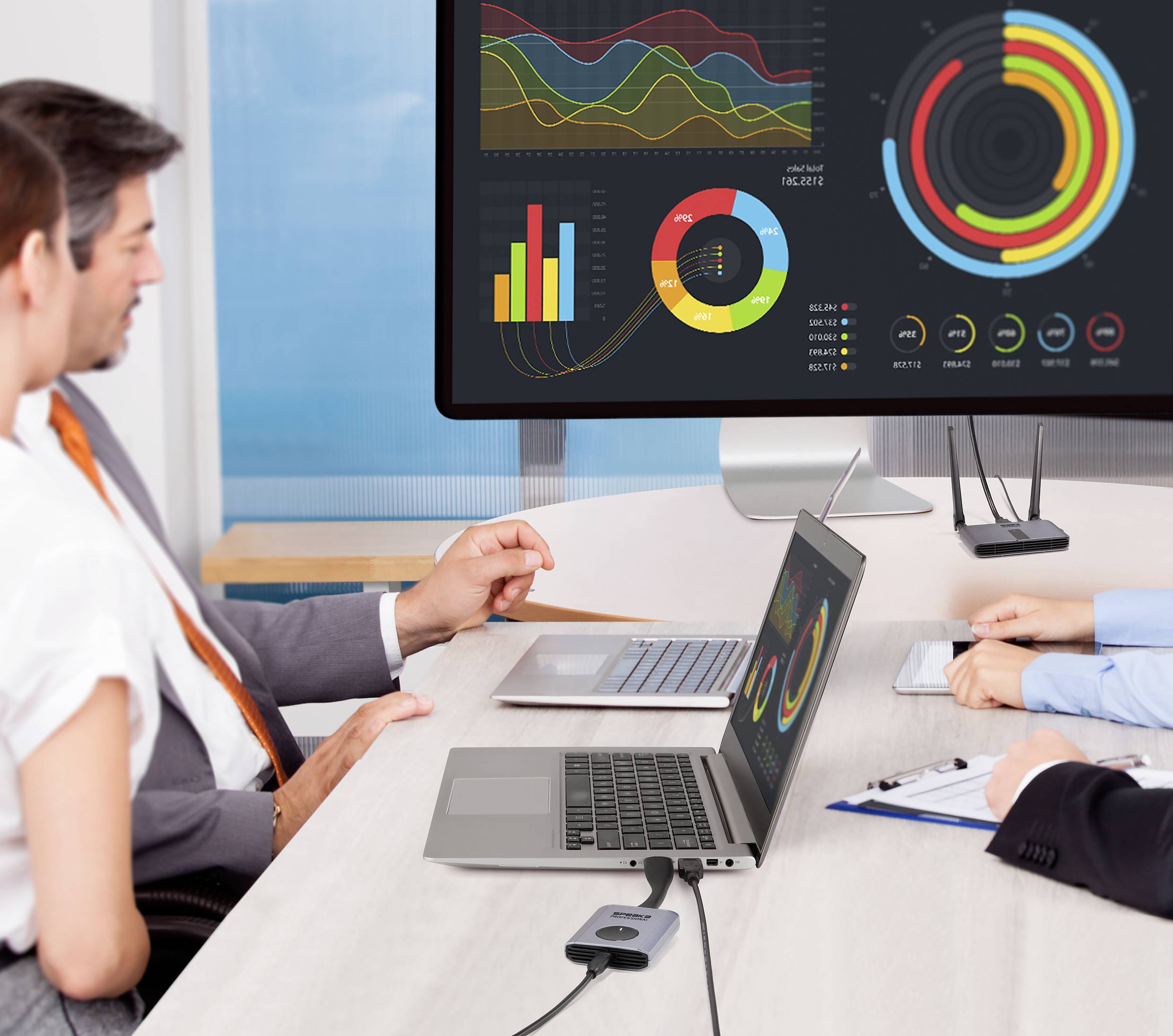 Persone in una sala riunioni stanno esaminando diagrammi su uno schermo. I dati riguardano analisi di performance e tendenze.