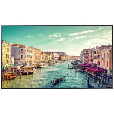 Veduta del Canal Grande a Venezia con gondole in transito e edifici colorati lungo la via d'acqua, sotto un cielo soleggiato.