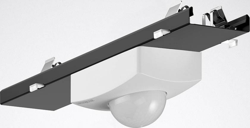 Una telecamera moderna montata su un supporto grigio. La telecamera ha un involucro liscio, bianco e un obiettivo semicircolare.