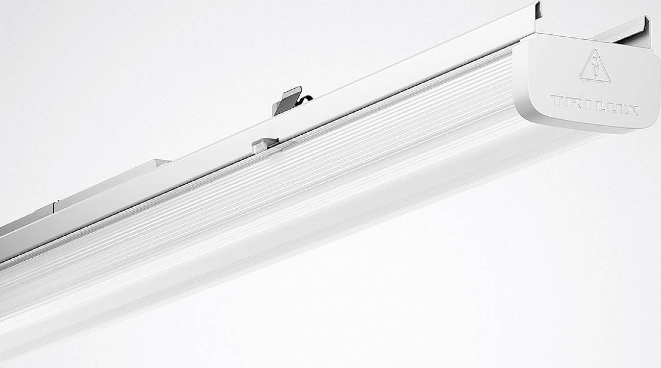 Una striscia luminosa LED bianca e moderna con la scritta 'TRILUX' sul lato, adatta per l'illuminazione industriale.