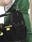 Un artigiano in abiti da lavoro verdi tiene una borsa degli attrezzi nera con utensili gialli e neri al suo fianco.