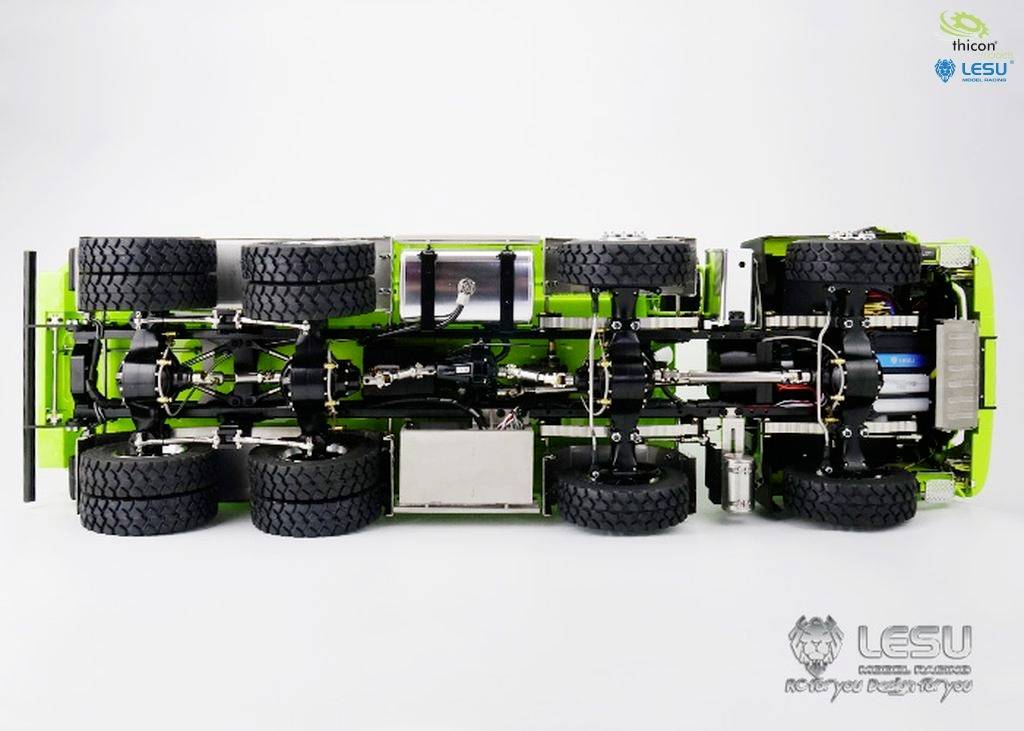 Veduta dal basso di un telaio verde per un camion RC, con disposizione completa di ruote e assali, su sfondo bianco.