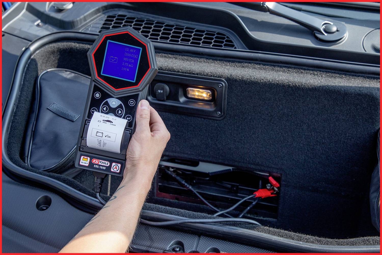 Una persona tiene in mano un dispositivo diagnostico collegato a un'automobile. Il dispositivo mostra i dati su un piccolo schermo.