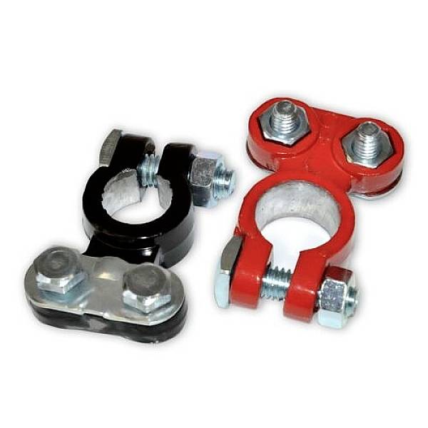Due morsetti di batteria per auto, uno nero e uno rosso, sono posizionati uno accanto all'altro. Hanno viti metalliche per il fissaggio sulla batteria.