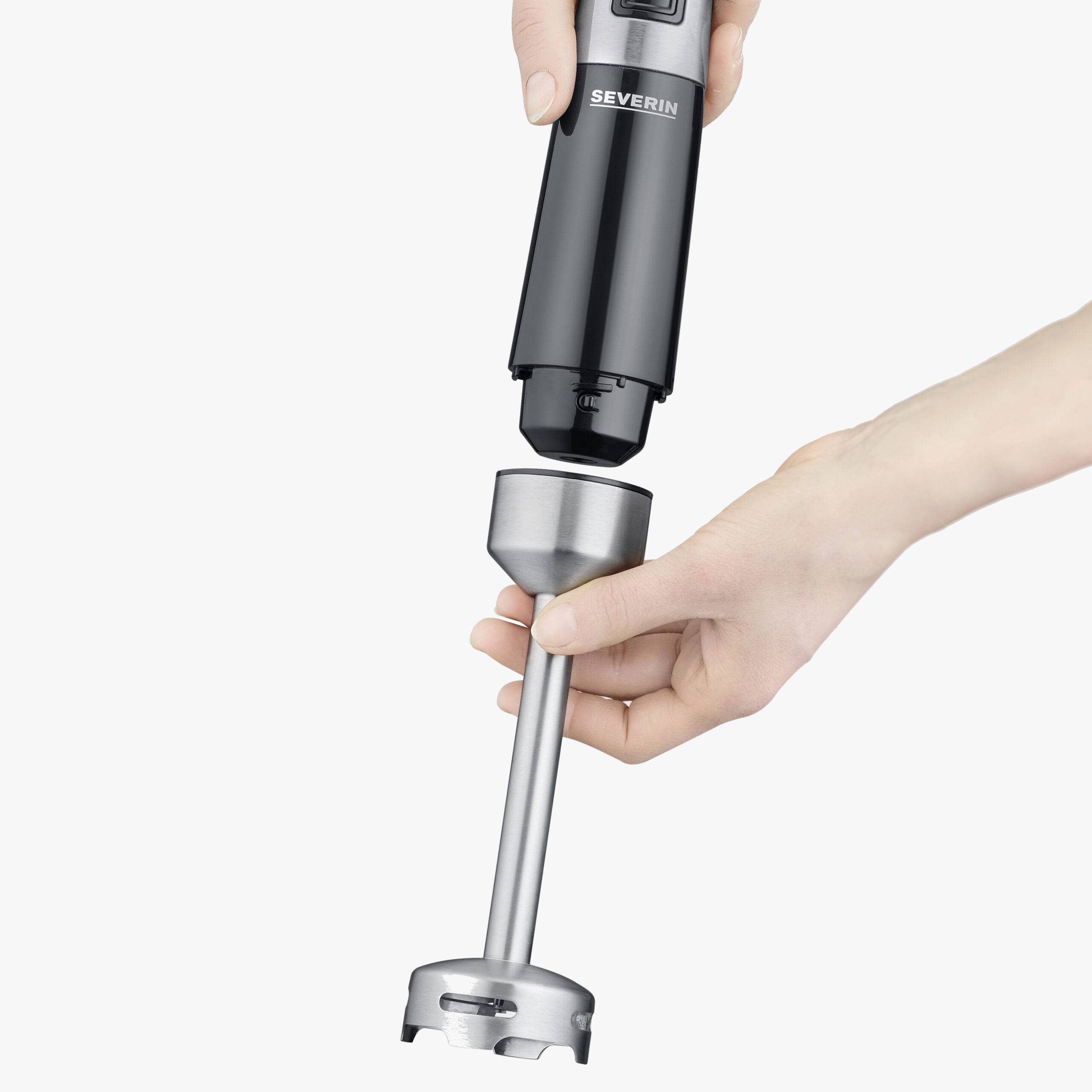 Una mano tiene un contenitore nero per frullatore a immersione e inserisce l'accessorio per assemblare l'apparecchio.