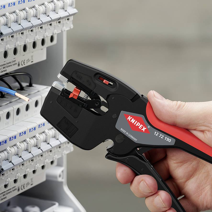Un utensile taglia i fili in un quadro elettrico. Una mano tiene la pinza, progettata per precisione ed efficienza.