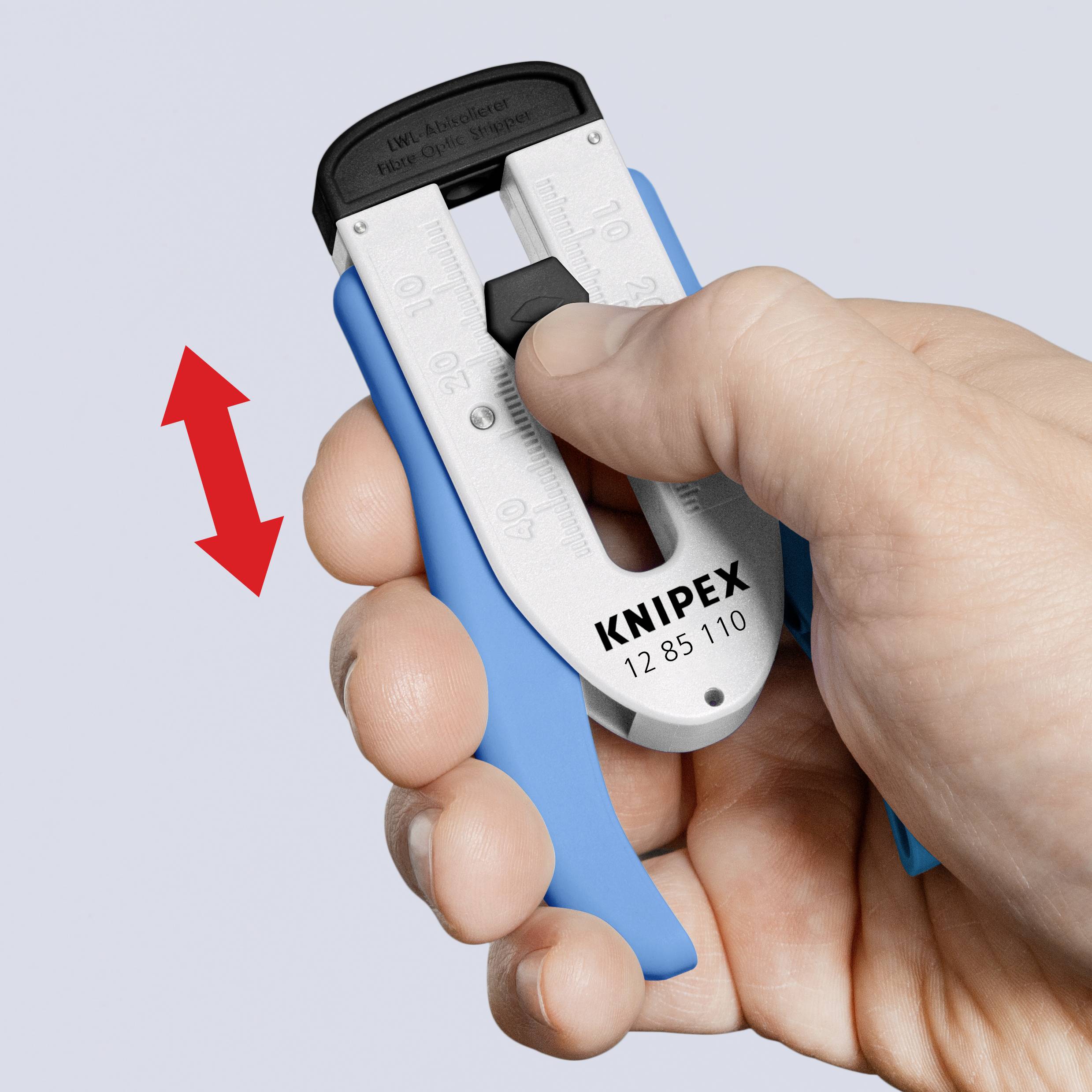 Una mano tiene una pinza spela fili blu di Knipex. Una freccia doppia rossa indica il movimento di spellatura dello strumento.
