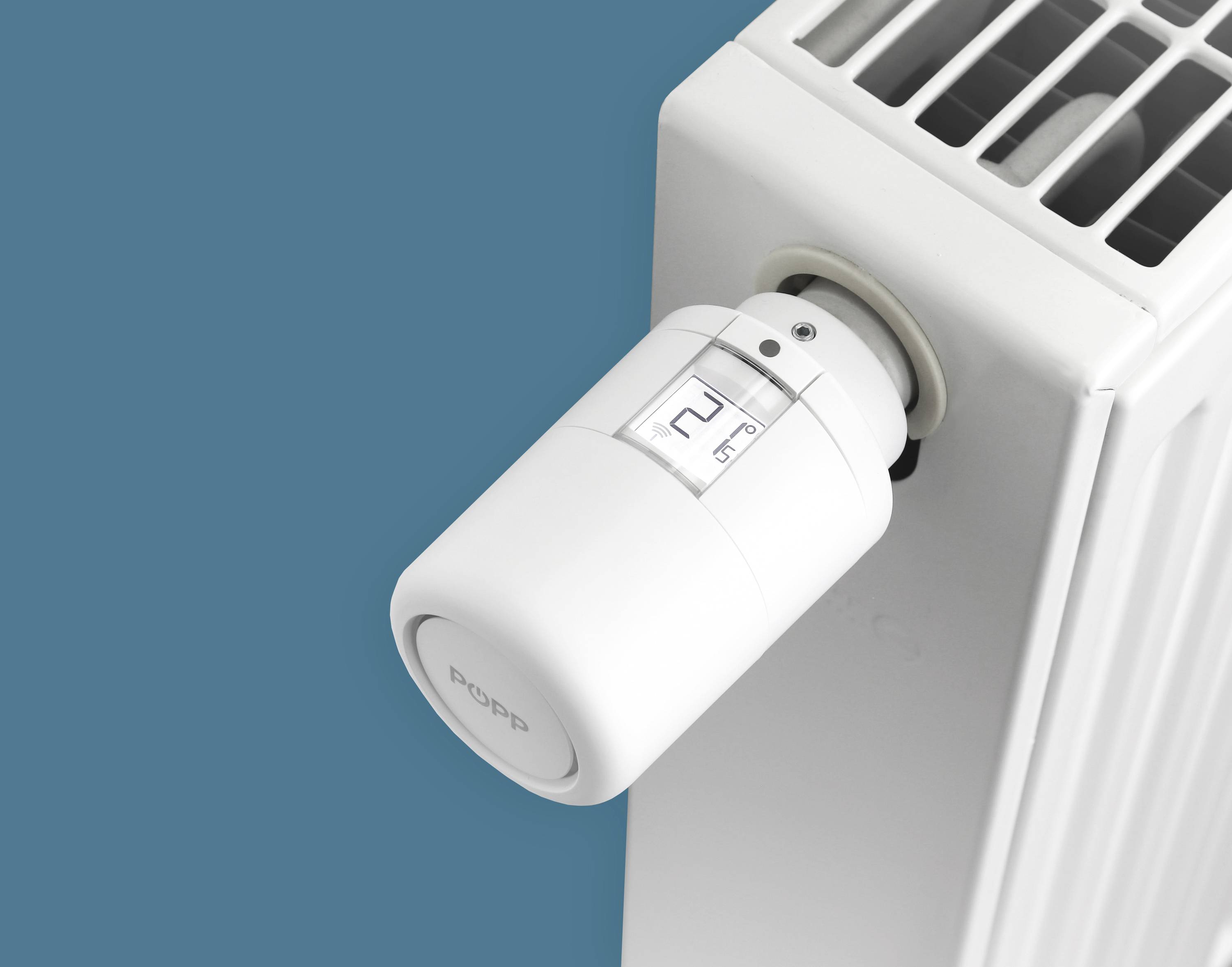 Un radiatore bianco con un termostato digitale su sfondo blu che mostra il controllo della temperatura.