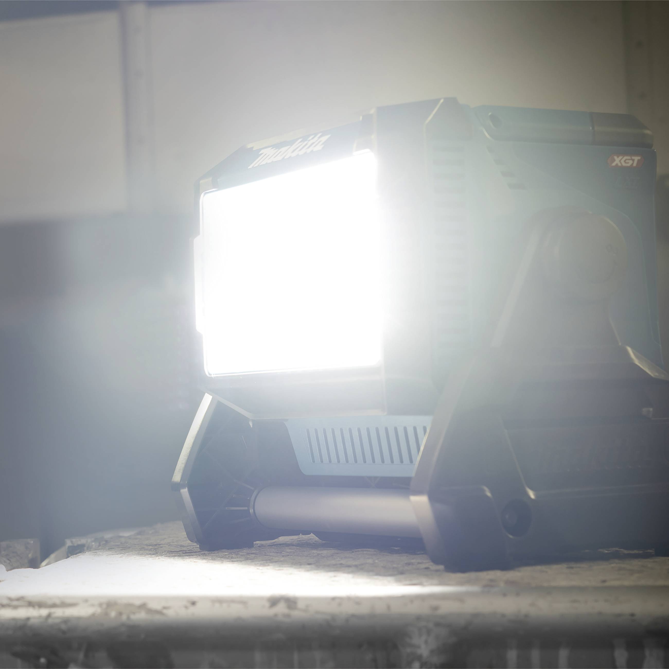 Un faro LED luminoso illumina una superficie di lavoro per illuminare un ambiente di officina o di cantiere.