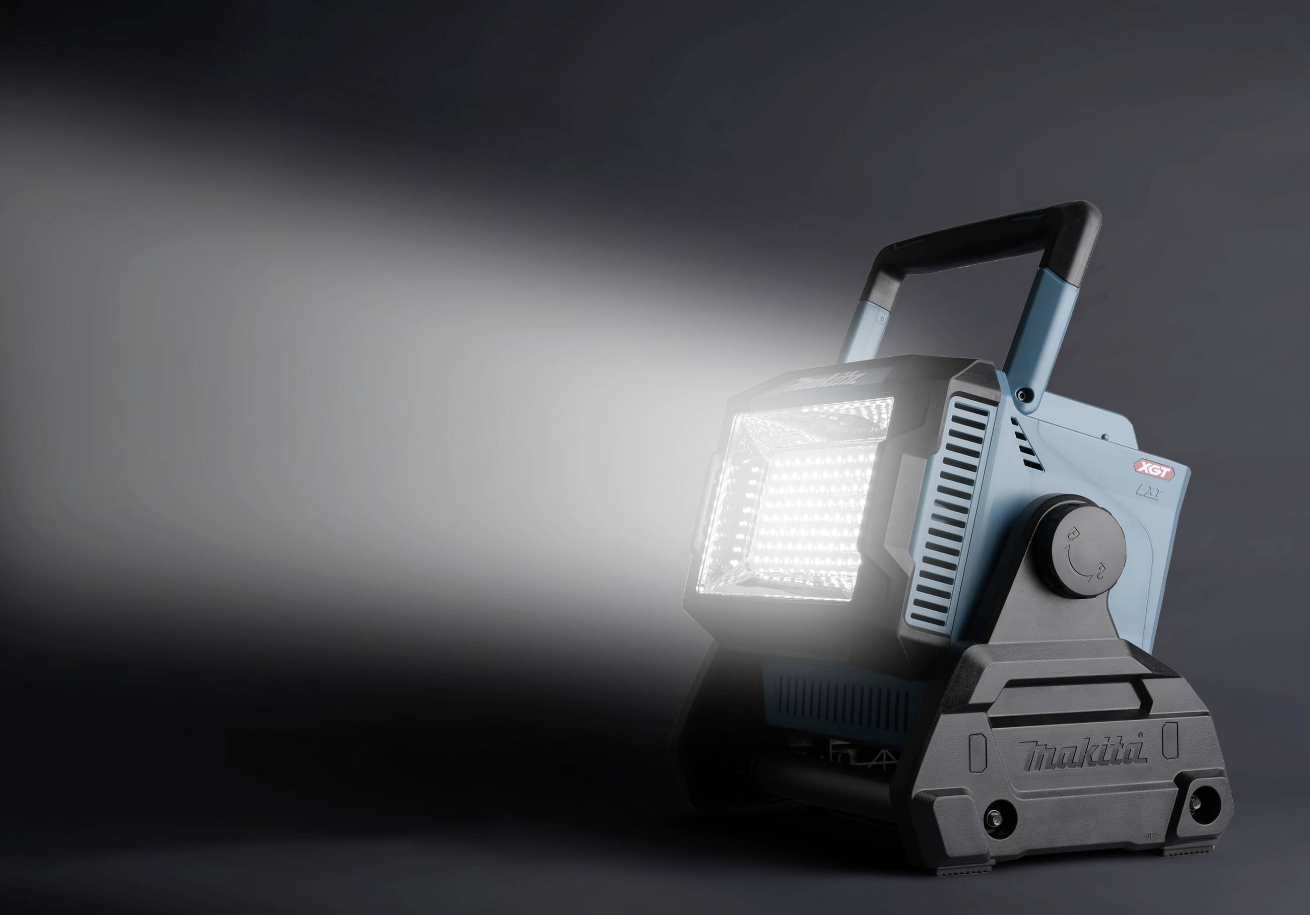 Lampada da cantiere portatile a LED, blu-nero, illumina intensamente verso sinistra. Utilizzata nei cantieri per condizioni di visibilità ottimali.