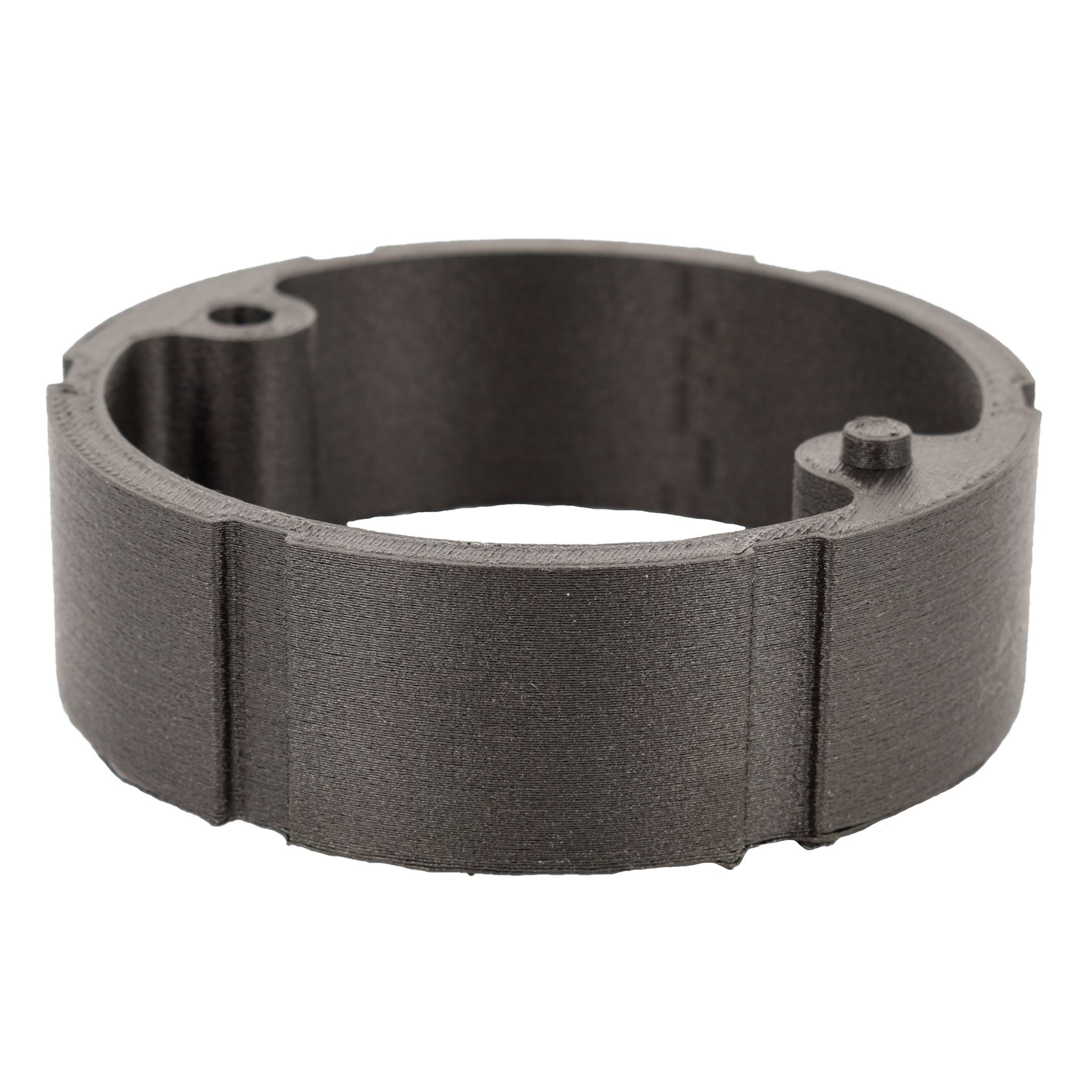 Anello nero, cilindrico, in plastica con due piccoli fori e un bordo rialzato su un lato.